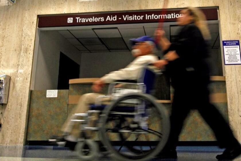 Orr, Francine –– – LOS ANGELES, CA – JUNE 24, 2011: A traveler in a wheelchair is pushed past the Travelers Aid– Visitors Information booth in Terminal one at LAX in Los Angeles, CA June 24, 2011. There was no one attending the booth. (Francine Orr / Los Angeles)