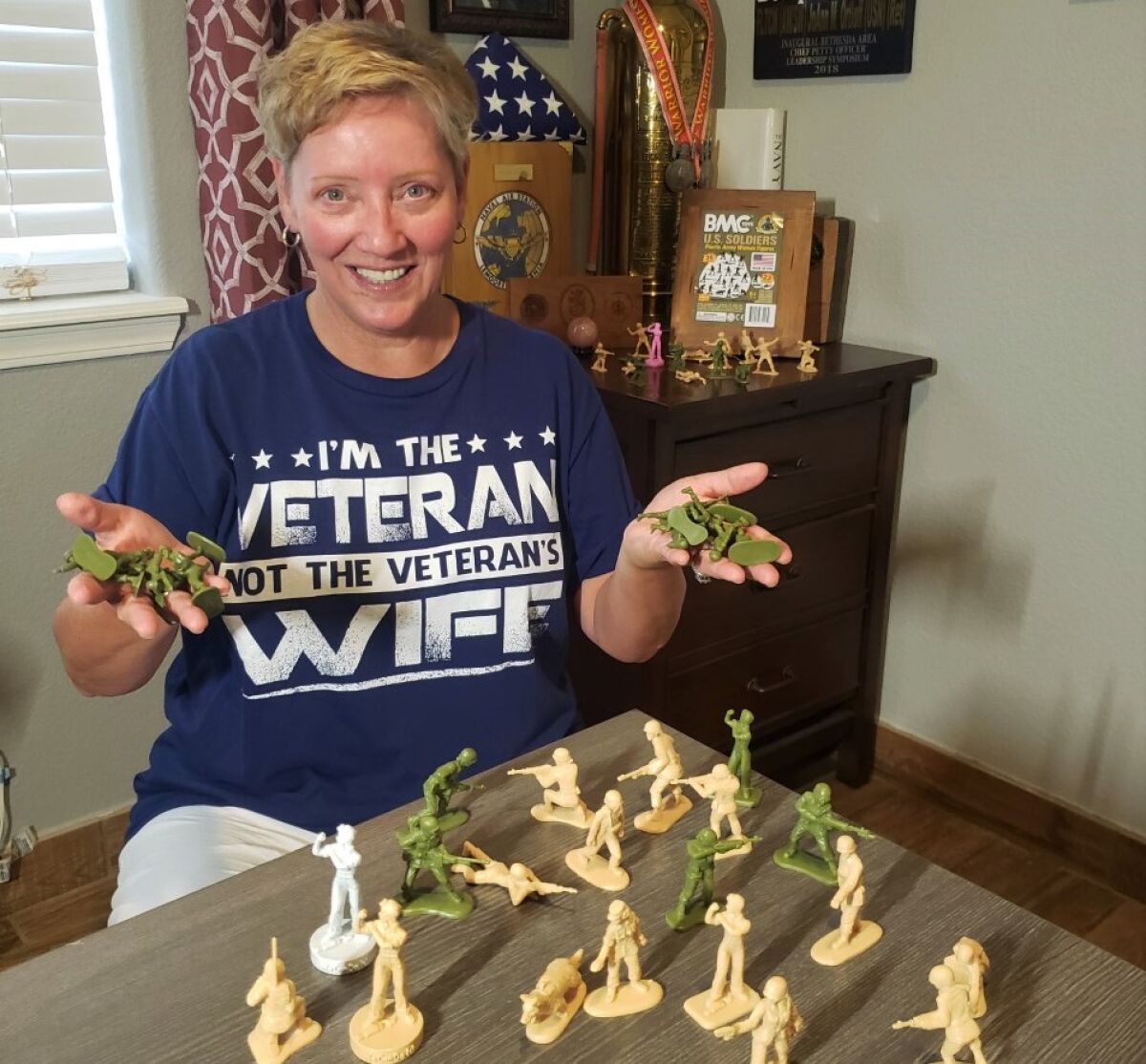 JoAnn Ortloff, proudly wearing her T-shirt, displays the first female toy soldiers by BMC Toys.