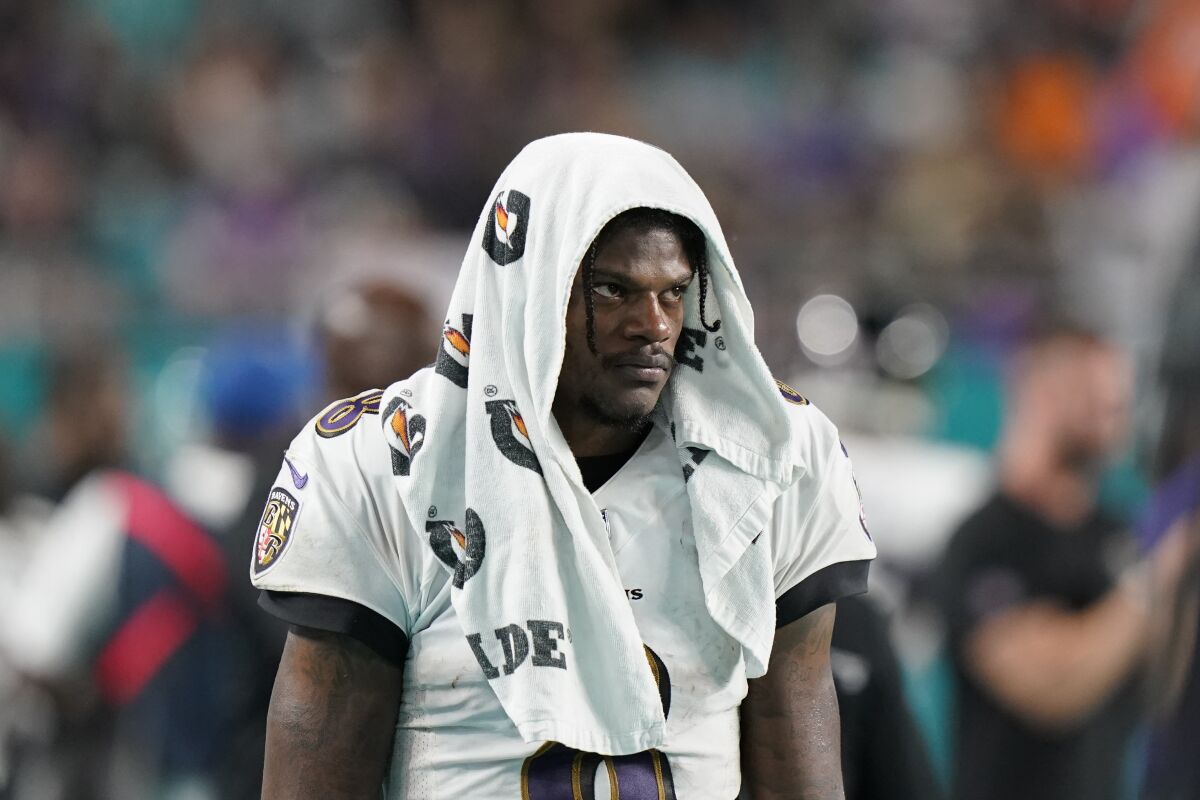 Baltimore Ravens quarterback Lamar Jackson (8) walks with a towel on his head during the second half of an NFL football game against the Miami Dolphins, Thursday, Nov. 11, 2021, in Miami Gardens, Fla. (AP Photo/Lynne Sladky)