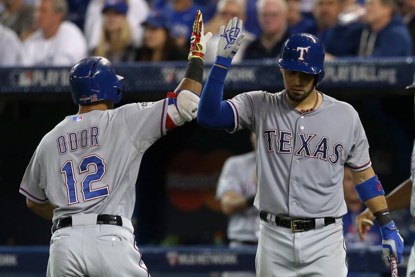 Rougned Odor (12) of the Texas Rangers celebrates with teammate Robinson Chirinos after scoring on a solo home run against Toronto's David Price in the seventh inning.