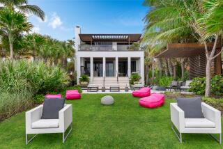 Recently remodeled, the three-story villa opens to a leafy backyard that leads right to the beach.