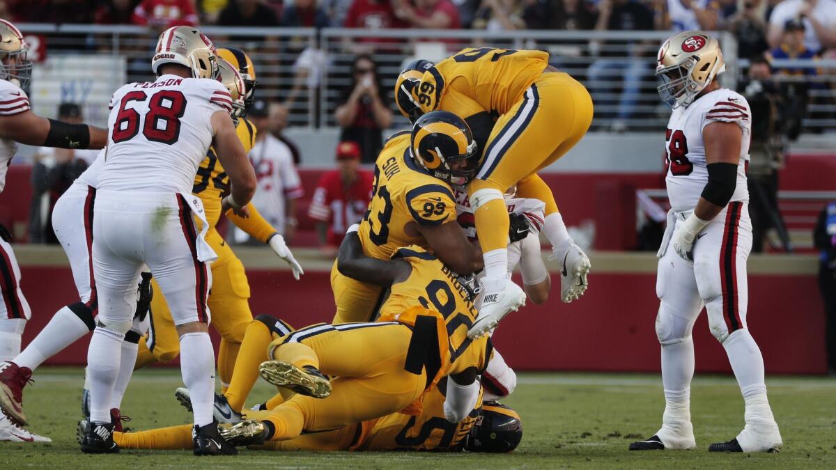Rams defensive tackle Aaron Donald (99) jumps on top of defensive tackles Ndamukong Suh (93) and Michael Brockers (90) to sack San Francisco 49ers quarterback C.J. Beathard (3).