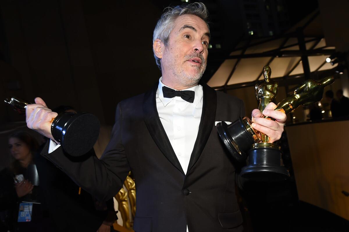 Alfonso Cuarón celebra sus tres premios tras la ceremonia del Oscar.