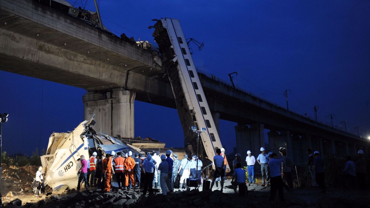 This photo taken on July 24, 2011 shows workers clearing wreckage after a Chinese high-speed train derailed and carriages fell off the elevated track.