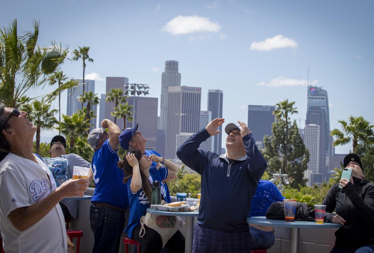 Dodgers fans watch the U.S. Army Golden Knights parachute into Dodger Stadium.