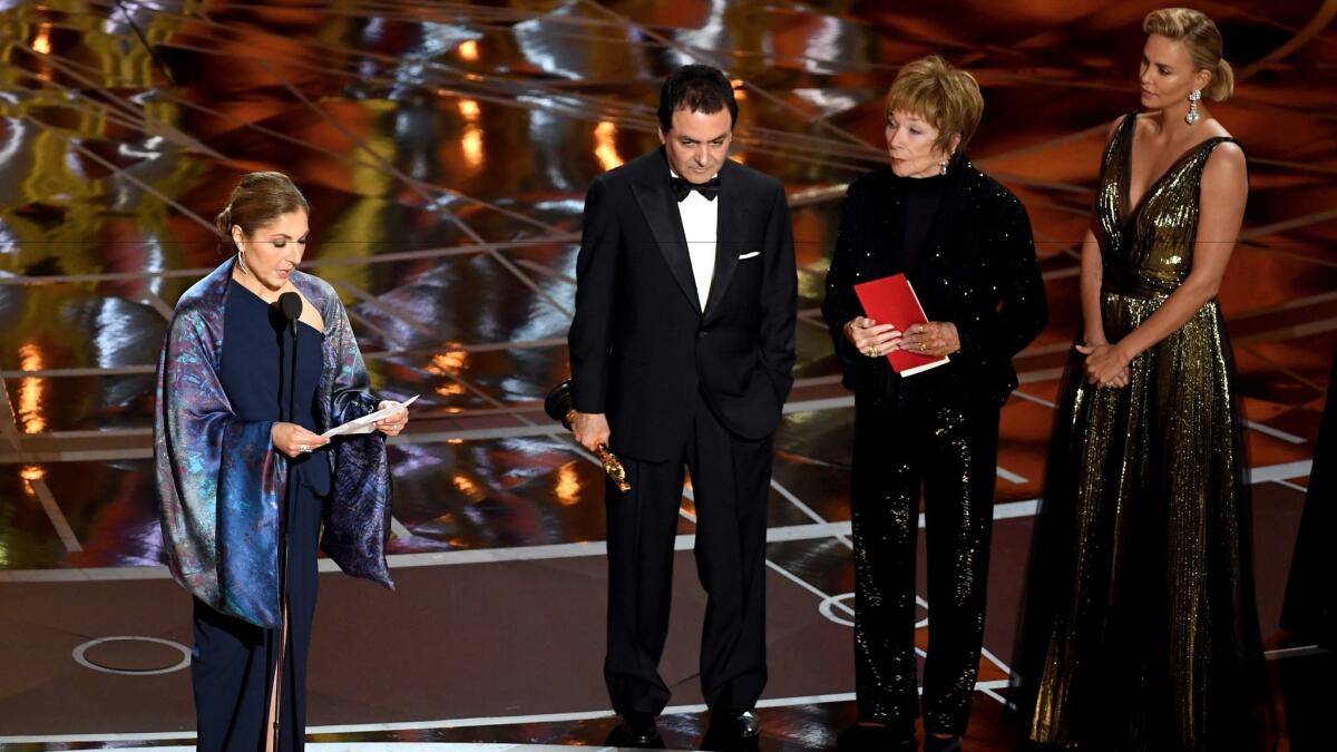 Anousheh Ansari reads a statement on behalf of "The Salesman" director Asghar Farhadi, who won for foreign language film. To her right are former NASA scientist Firouz Naderi with Shirley MacLaine and Charlize Theron.