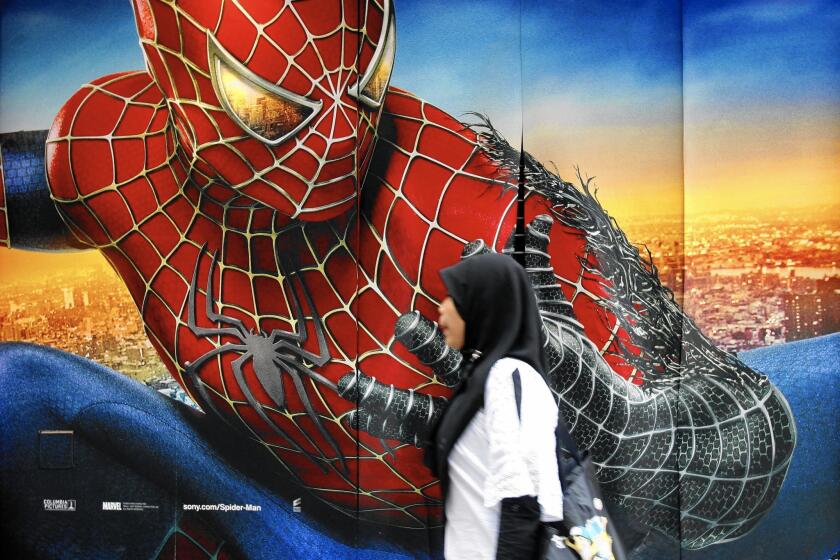 A woman walks past a "Spider-Man 3" poster in Hong Kong in 2007.
