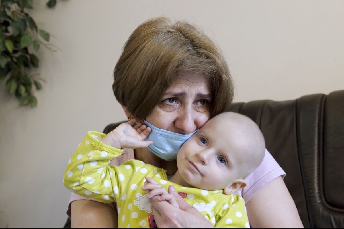 A Ukrainian grandmother holds her 22-month-old granddaughter with leukemia, Yeva Vakulenko, at a clinic in Bocheniec, Poland, on Thursday, March 17, 2022. Vakulenko is among more than 500 Ukrainian children with cancer who have been evacuated so far to a clinic in Poland. They are evaluated by doctors who then decide where they should go next for treatment. Some 200 hospitals in about 28 countries are accepting the children. (AP Photo/Pawel Kuczynski)
