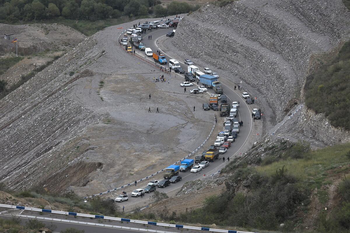 Aerial view of long line of vehicles on mountain road