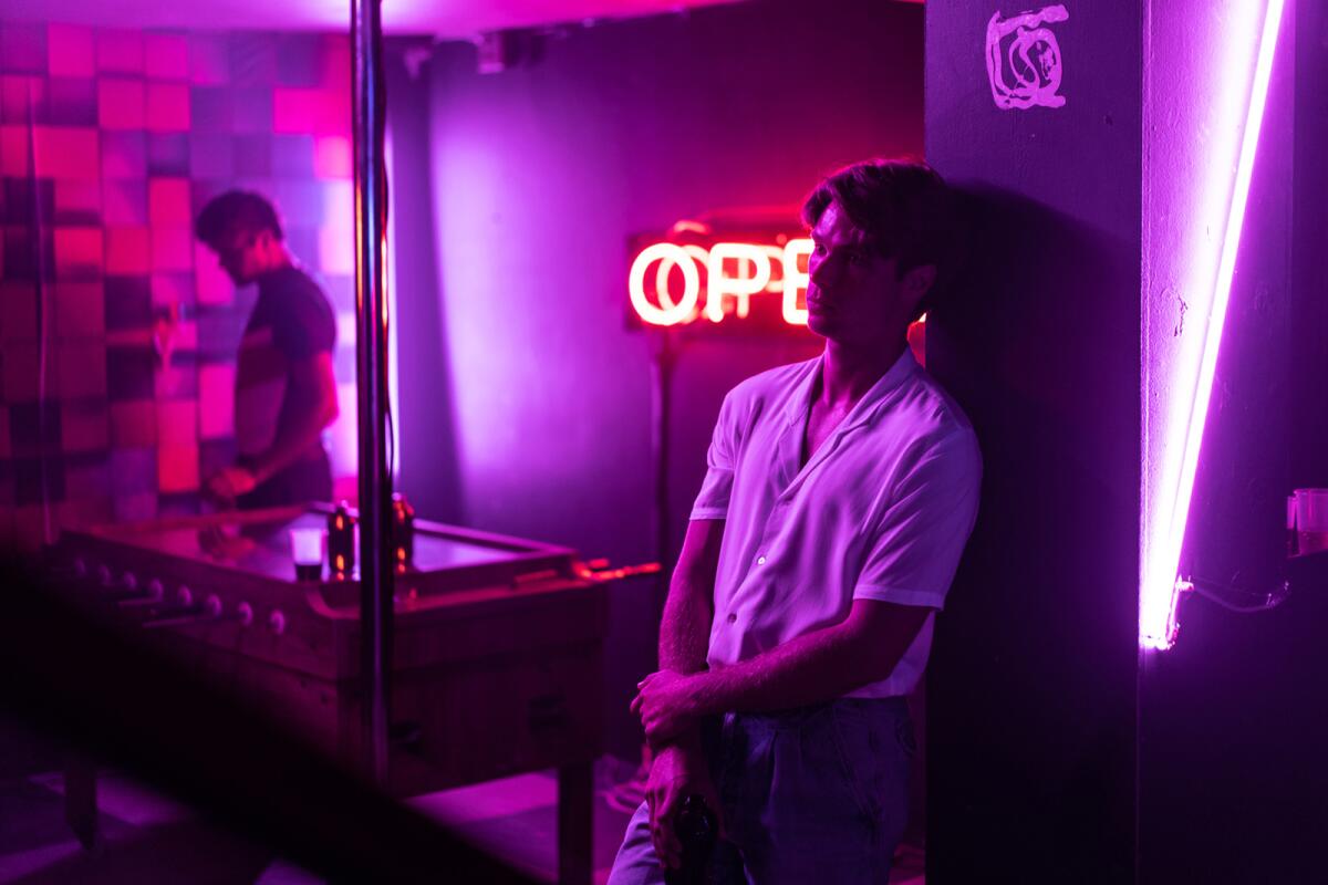 Kai Luke Brummer relaxes in a bar in the movie "Moffie."