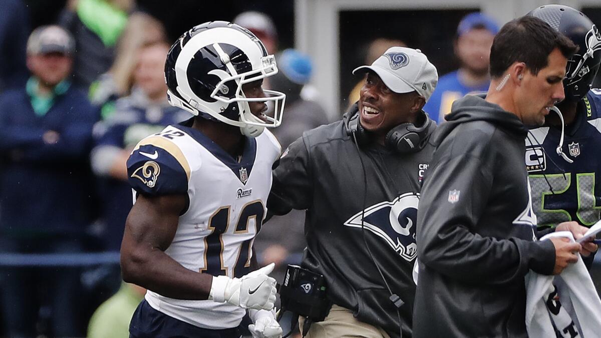 Rams wide receiver Brandin Cooks leaves the field with an assistant coach after a hard hit by Seattle defensive back Tedric Thompson.