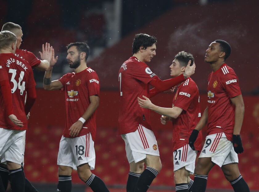 Manchester United players celebrate after Anthony Martial, right, scoring his side's eighth goal during the English Premier League soccer match between Manchester United and Southampton, at the Old Trafford stadium in Manchester, England, Tuesday, Feb. 2, 2021. (Phil Noble/Pool via AP)