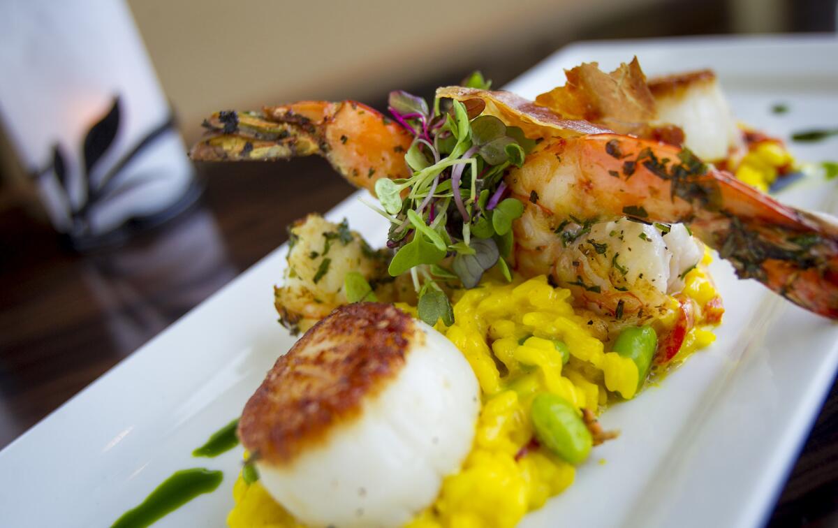 The seafood risotto at The Winery in Newport Beach includes Maine scallops and wild shrimp over saffron risotto, edamame, roasted red bell peppers, micro greens and basil oil.
