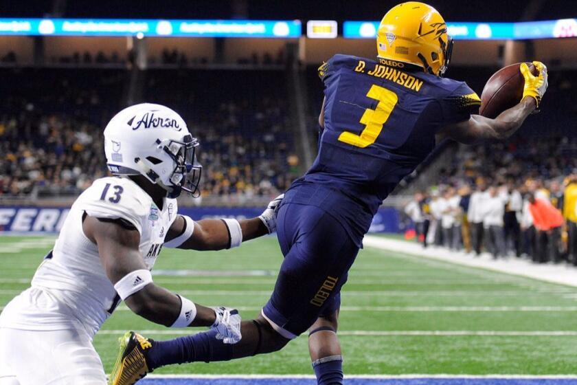 Toledo wide receiver Diontae Johnson (3) catches the ball for a touchdown past Akron defensive back Denzel Butler (13) during the second quarter of the Mid-American Conference championship NCAA college football game, Saturday, Dec. 2, 2017, in Detroit. Toledo retained possession of the ball. (AP Photo/Jose Juarez)