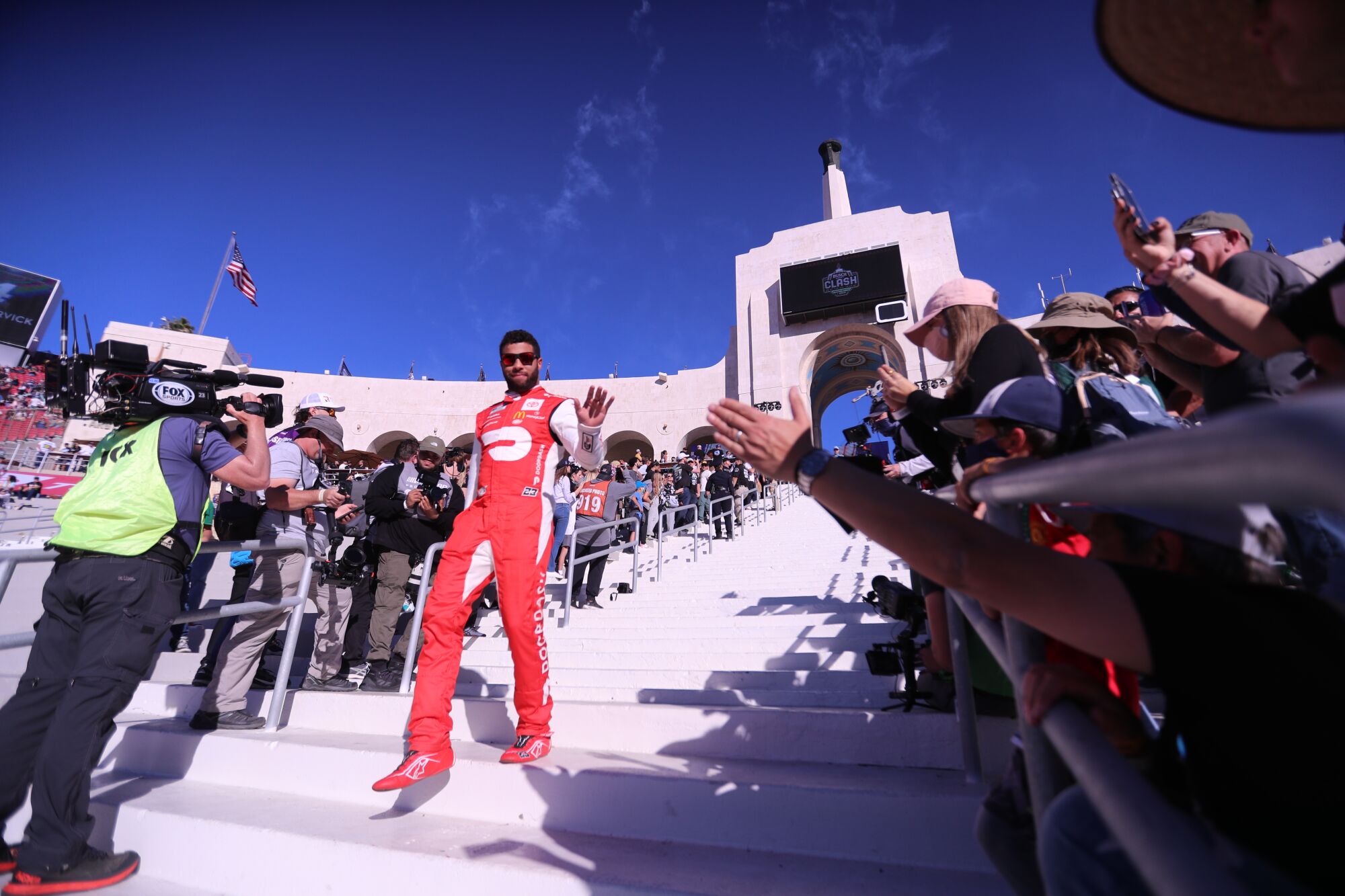 NASCAR racer Bubba Wallace walks down the staircase to the track as he is introduced