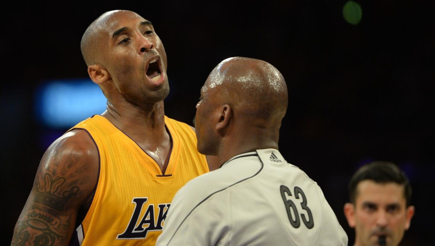 Kobe Bryant confronts Houston center Dwight Howard after getting elbowed in the face during the fourth quarter of the Lakers' season-opening loss to the Rockets, 108-90.