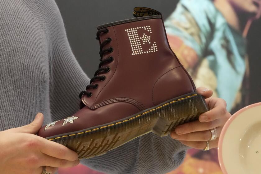 FILE - A Dr Martens boot inspired by Elton John's famous Pinball Wizard outfit is shown at a promotional event in London, March 20, 2023. Dr. Martens shares plunged more than 30% Tuesday, April 16, 2024 after the trendy British brand forecast that wholesale revenue in the U.S., its largest market, would decline by double-digits compared to that seen a year ago. (AP Photo/Kin Cheung, File)