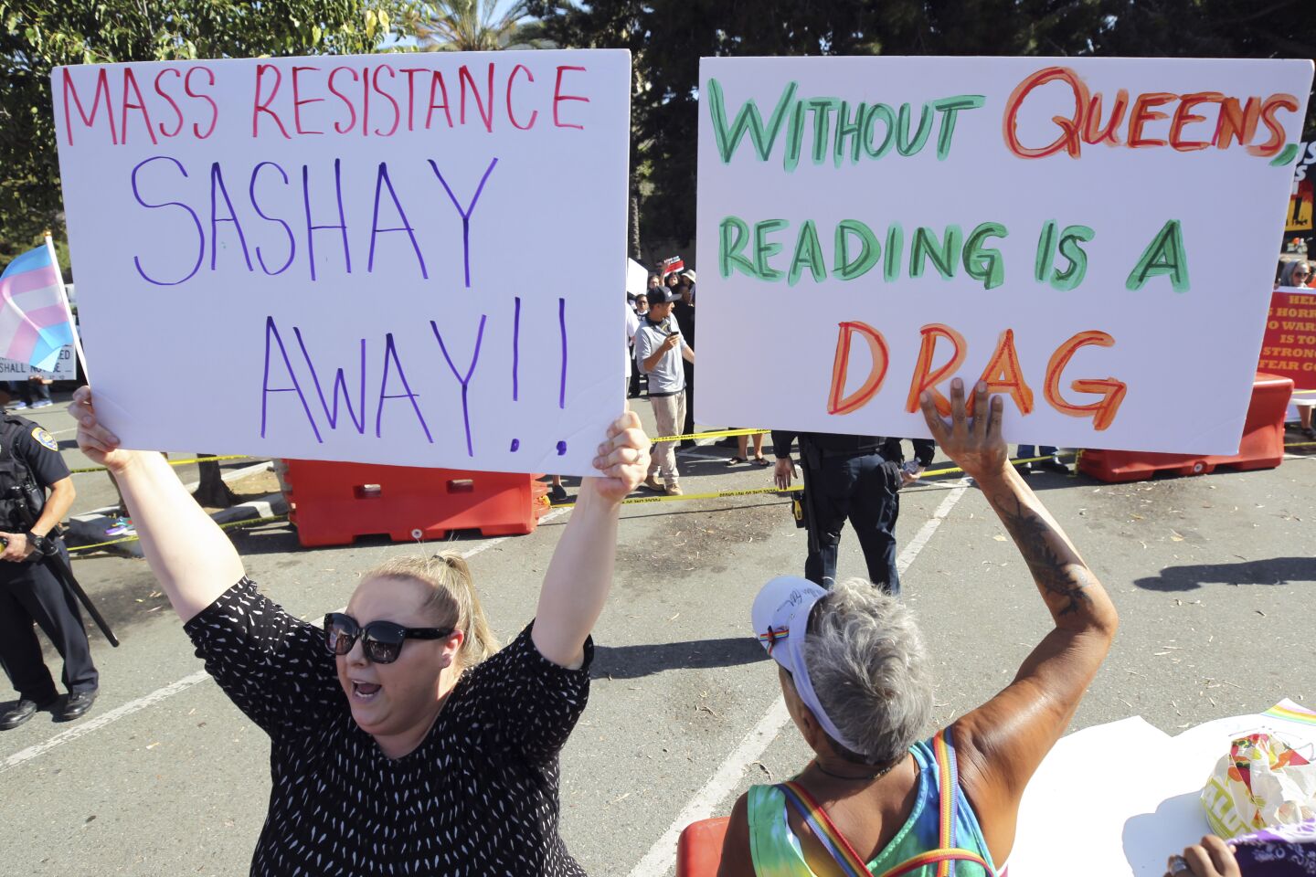 Supporters of the Drag Queen Story Hour Hannah Usher, left, and her mother Coyote Moon hold up signs at the Chula Vista Public Library, Civic Center Branch, on Tuesday, September 10, 2019 in Chula Vista, California.