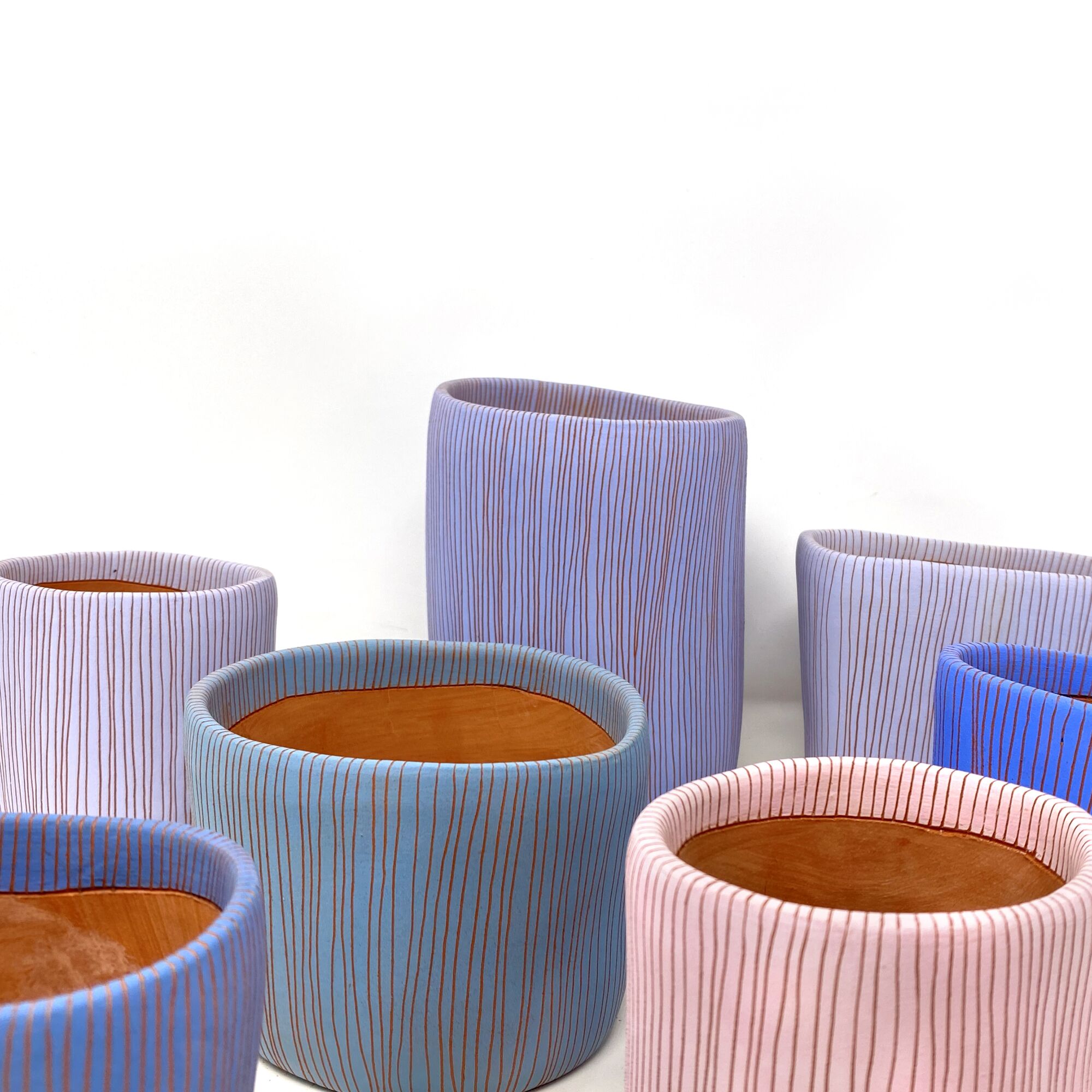 Three ceramic bowls carved with fine lines come in shadows of blue, turquoise and pink.