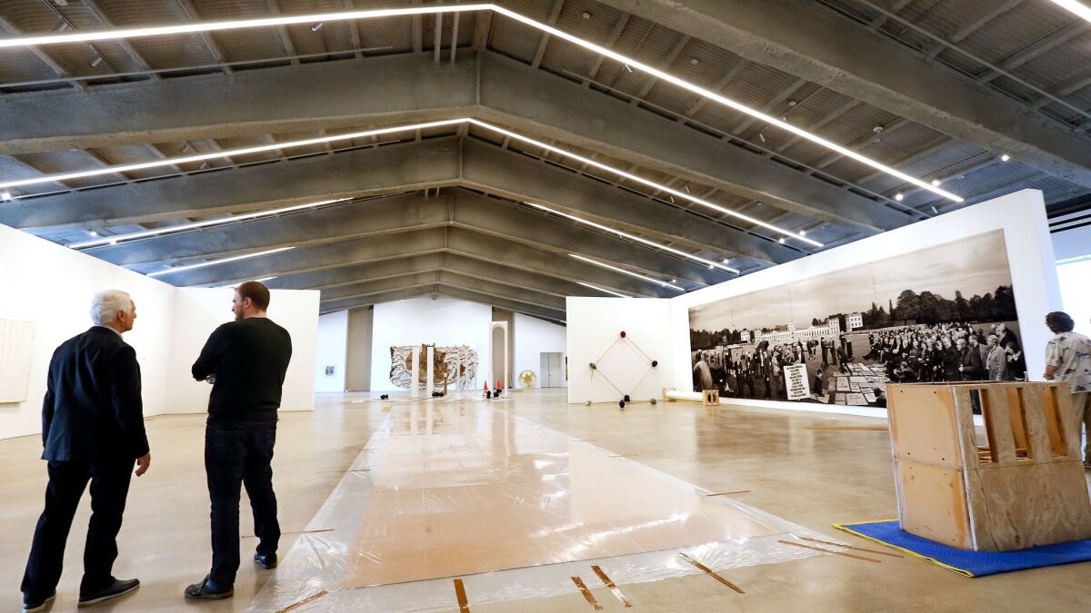 Maurice Marciano, left, photographed on the third floor of during the installation of the opening exhibition, "Unpacking: The Marciano Collection."