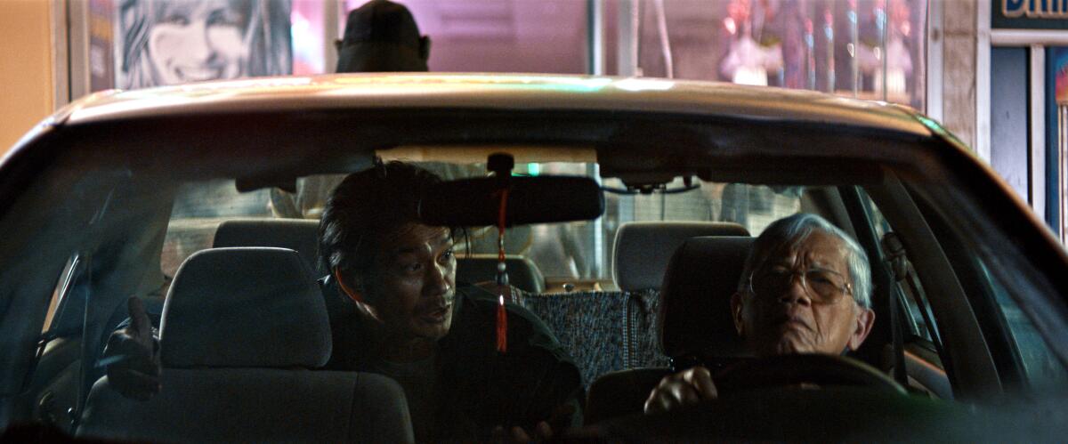 A man in the back seat of a car argues with the driver.