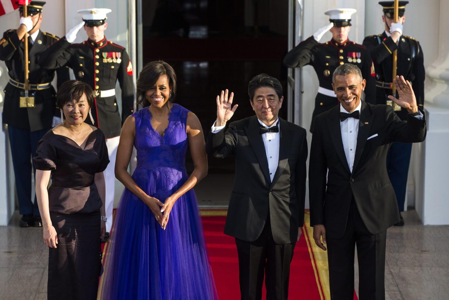 Michelle Obama dons a rich purple gown by Japanese-born designer Tadashi Shoji at Tuesday night's state dinner for Japan honoring Prime Minister Shinzo Abe and his wife, Akie.
