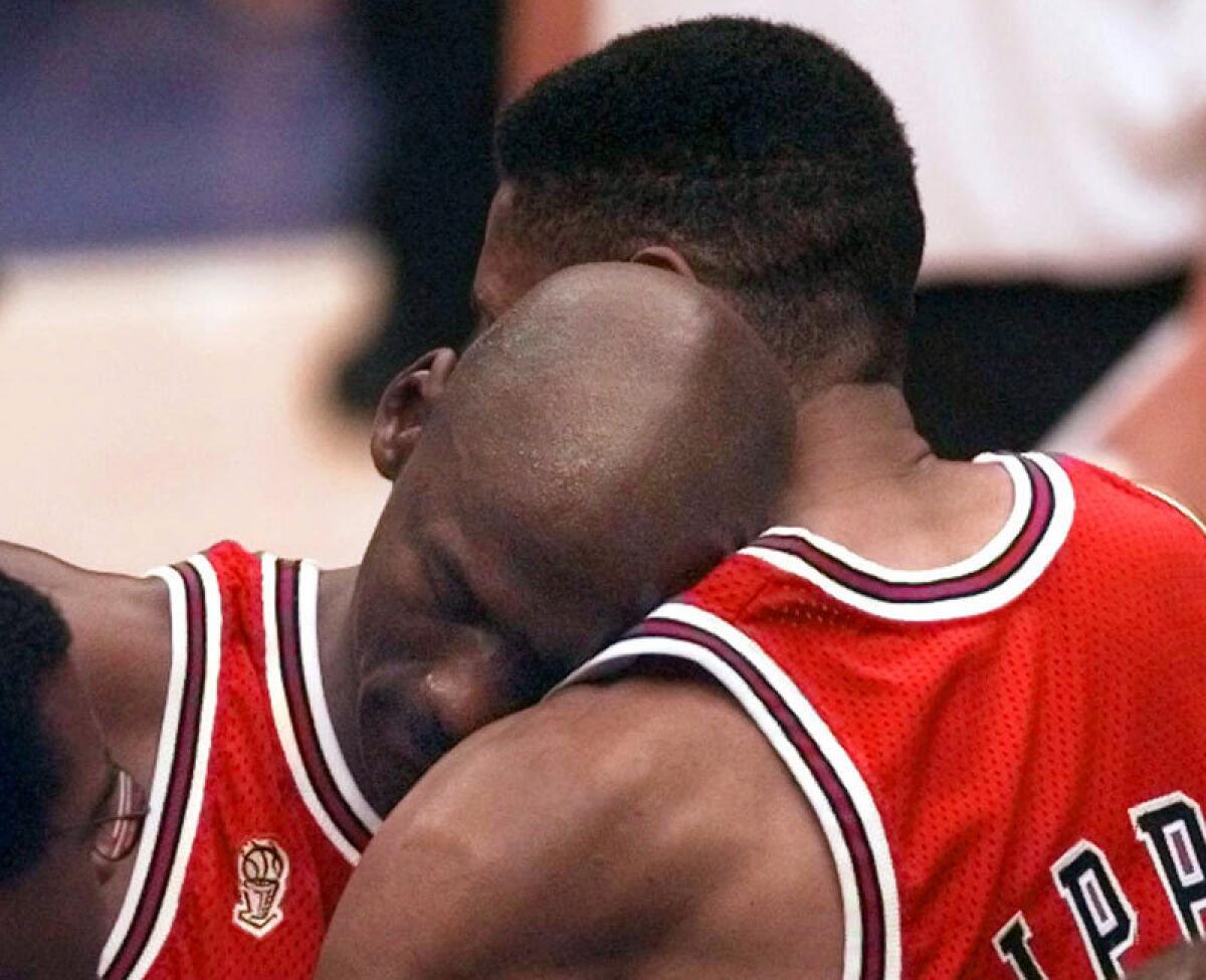An ailing Michael Jordan leans on teammate Scottie Pippen after scoring 38 points to lead the Bulls to victory in the "Flu Game" in the 1997 NBA Finals.