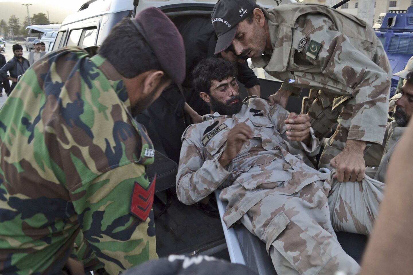 Pakistani paramilitary soldiers carry a colleague who was wounded during a gun battle at a hospital in Quetta.