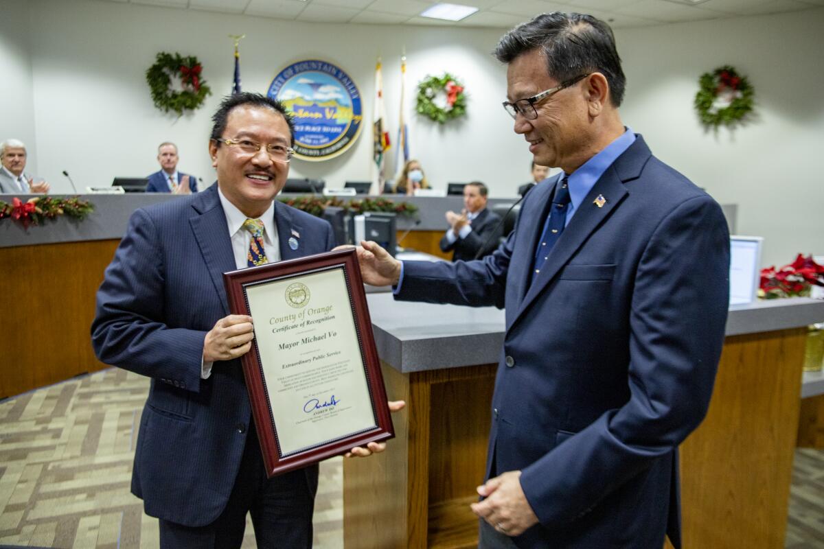 Orange County Supervisor Andrew Do, right, awards outgoing mayor Michael Vo the Orange County Certificate of Recognition.