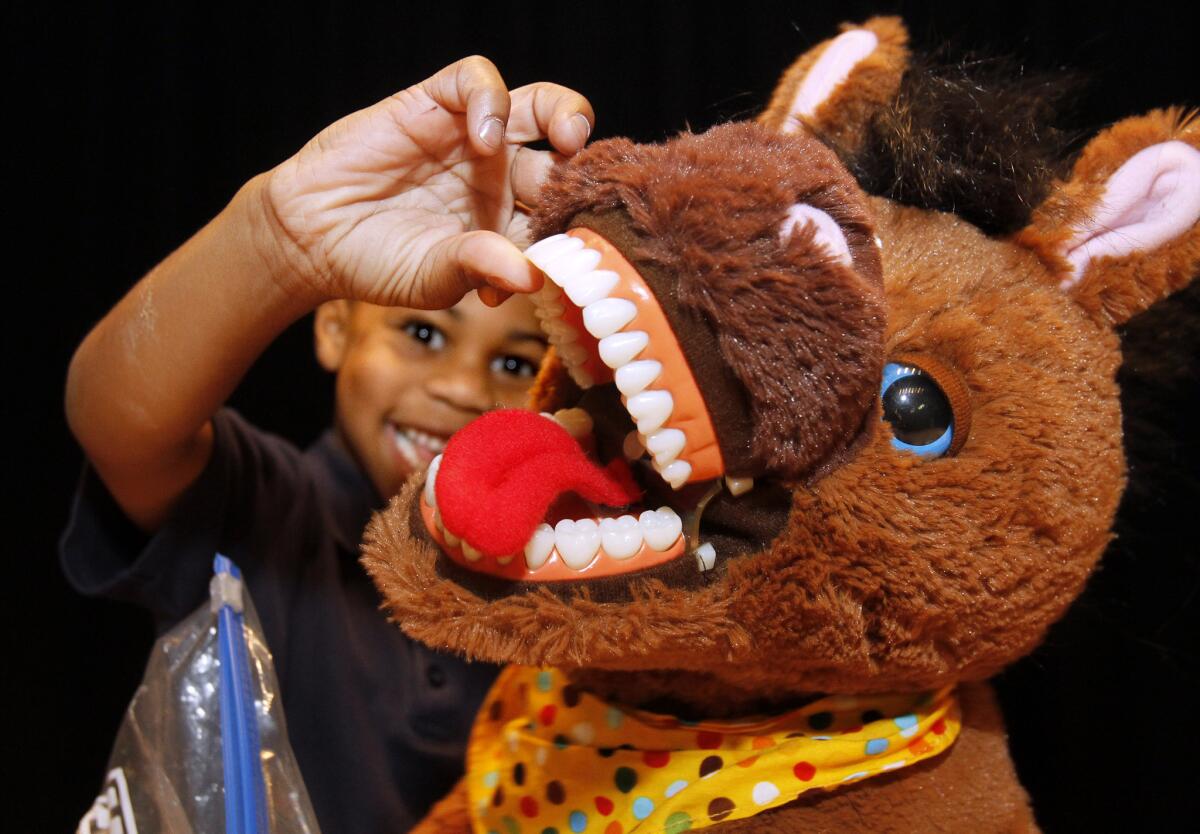Kindergartener Jamaal Bradford, 6, looks at a stuffed horse's teeth during the "Give Kids A Smile" day dental clinic at George Washington Elementary School in Burbank on Tuesday, Feb. 11, 2014. The event was sponsored in part by Henry Shein, Colgate, the American Dental Association and the Kids Community Dental Clinic.