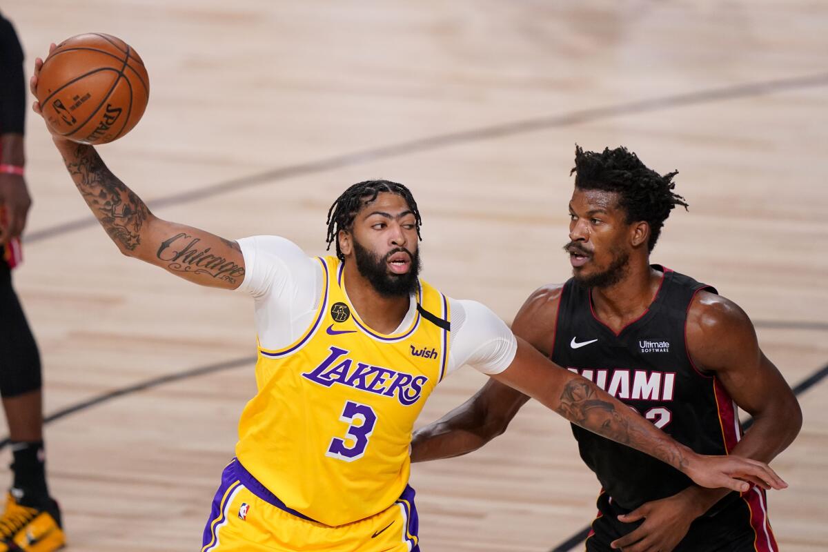 Lakers forward Anthony Davis drives around Heat forward Jimmy Butler during the first half in Game 4.