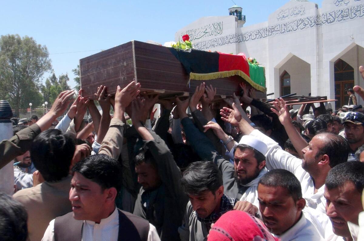 Afghans carry the body of a police officer killed in a border clash with Pakistani troops in the Goshta district of Nangahar province.