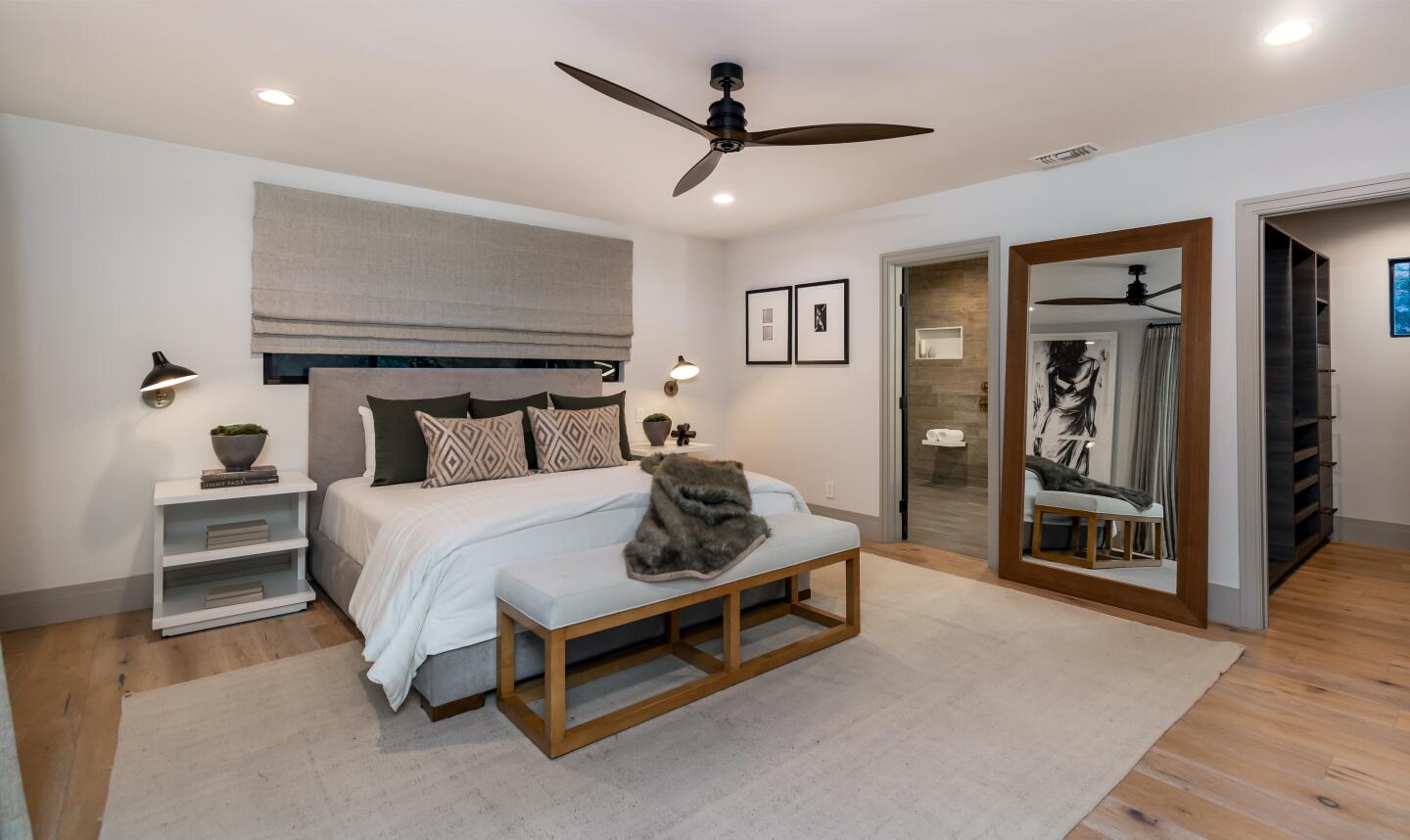 The furnished primary bedroom with a ceiling fan.