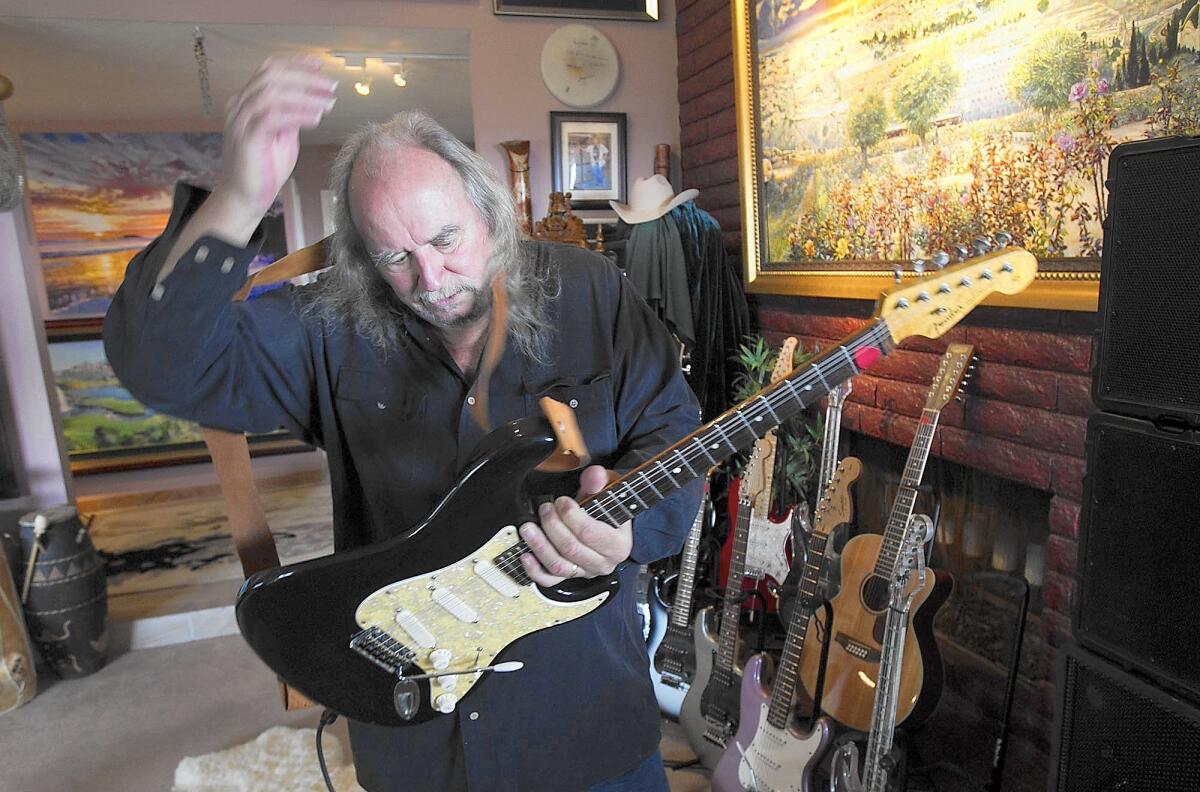Randy Holden picks up his favorite Fender guitar in his Dana Point home. Holden, 70, has played rock guitar most of his life, playing with bands including Blue Cheer, Fender IV and Sons of Adam. He has been invited to play the 2016 International Surf Convention and 2017 Roadburn Festival in Europe.