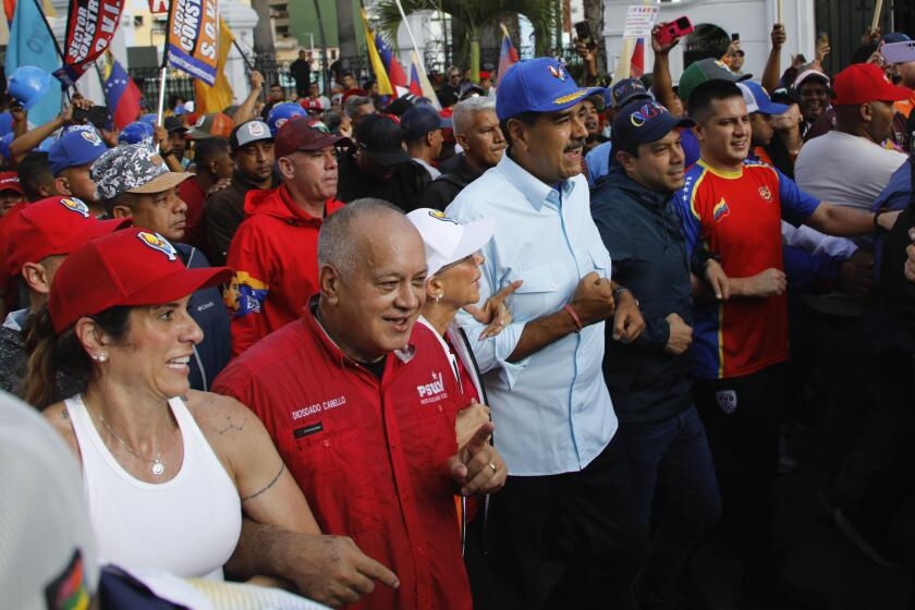 ARCHIVO - El presidente venezolano, Nicolás Maduro, en el centro, acompañado del legislador Diosdado Cabello, segundo por la izquierda, y de la primera dama Cilia Flores en una marcha por un acto oficialista en Caracas, Venezuela, el 17 de agosto de 2024. (AP Foto/Cristian Hernández, Archivo)