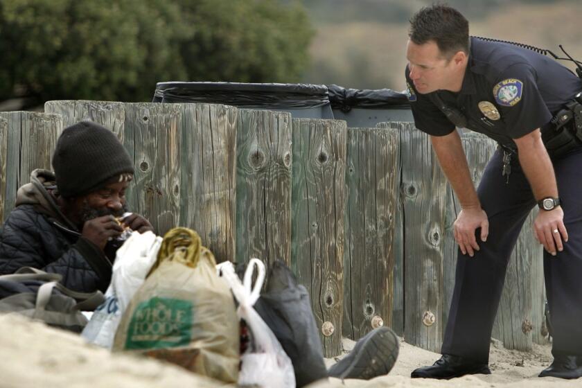 135806.ME.0401.homeless.MJB-(Laguna Beach)-Laguna Beach Police Officer Jason Farris talks with one of his homeless men on the Main Beach. Farris has the task of making contact with all of the city's homeless and helping them to help themselves. April 1, 2008