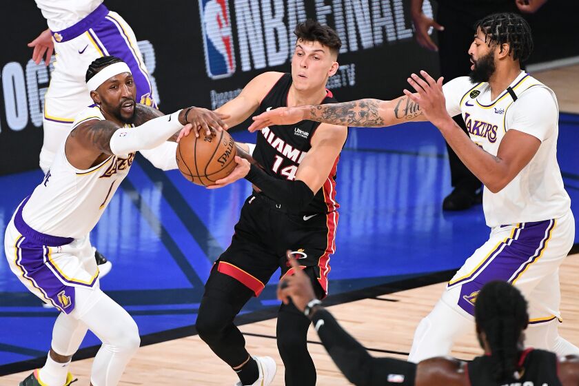 Lakers Kentavious Caldwell-Pope, left, and Anthony Davis apply defensive pressure to the Miami Heat's Tyler Herro 
