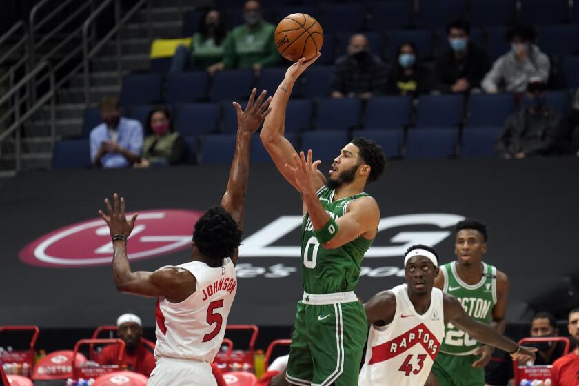 Boston Celtics forward Jayson Tatum (0) shoots over Toronto Raptors forward Stanley Johnson (5) during the first half of an NBA basketball game Monday, Jan. 4, 2021, in Tampa, Fla. (AP Photo/Chris O'Meara)