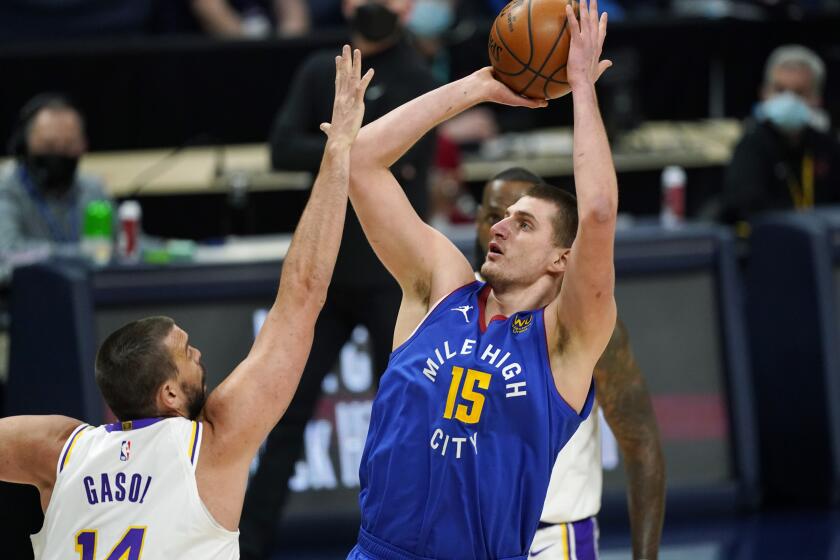 Denver Nuggets center Nikola Jokic, right, goes up to shoot over Los Angeles Lakers center Marc Gasol in the first half of an NBA basketball game Sunday, Feb. 14, 2021, in Denver. (AP Photo/David Zalubowski)