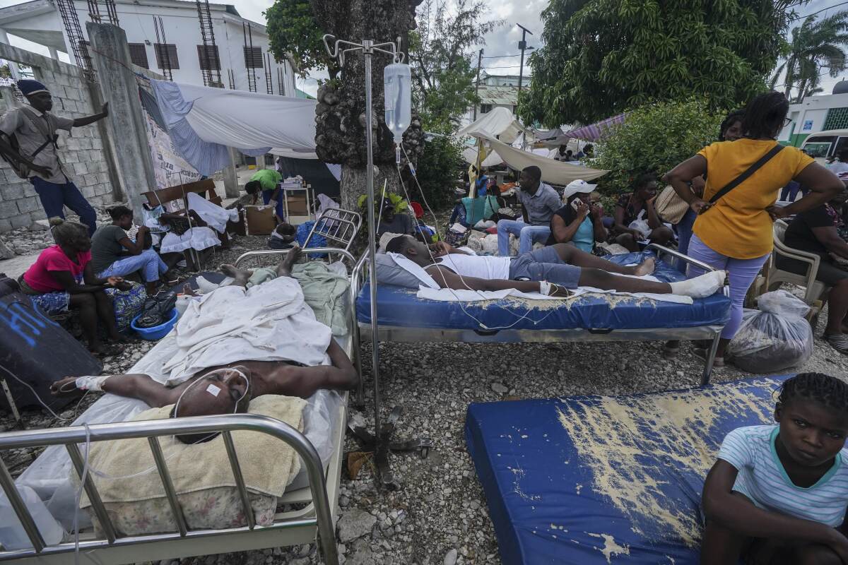 Injured people lying in beds outside a hospital