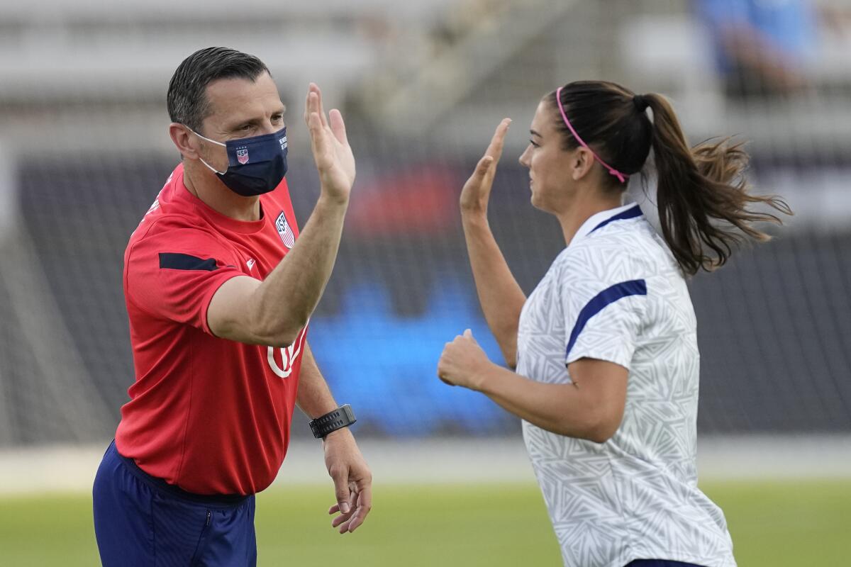 Vlatko Andonovski exchanges a high-five with Alex Morgan 