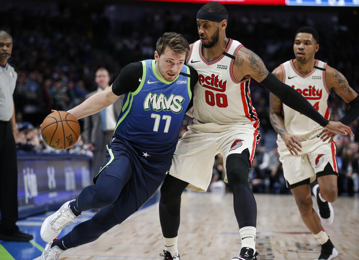 Dallas Mavericks forward Luka Doncic (77) drives as Portland Trail Blazers forward Carmelo Anthony (00) defends during the first half on Friday in Dallas.