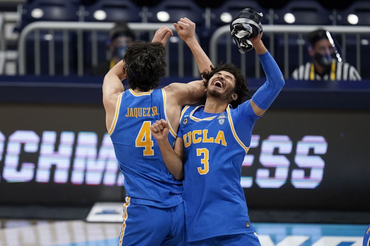 UCLA guard Jaime Jaquez Jr., left, and Johnny Juzang celebrate after the Bruins beat Alabama 88-78 in overtime.