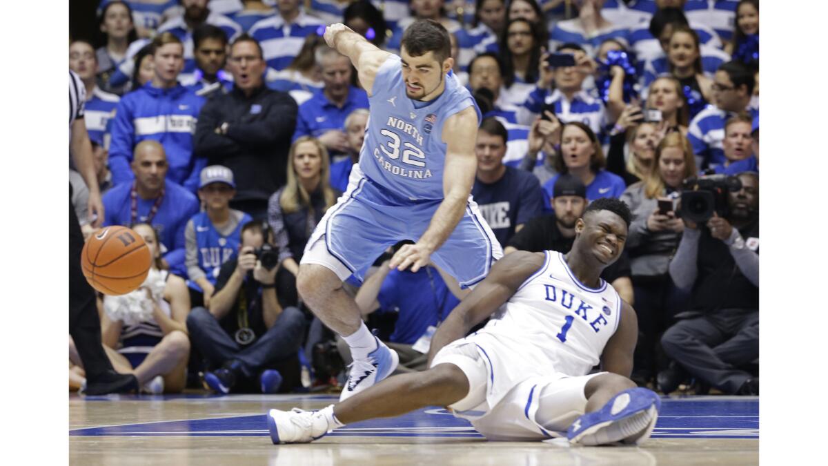Duke’s Zion Williamson falls to the floor with an injury while chasing the ball with North Carolina’s Luke Maye during the first half of an NCAA college basketball game Feb. 20 in Durham, N.C.