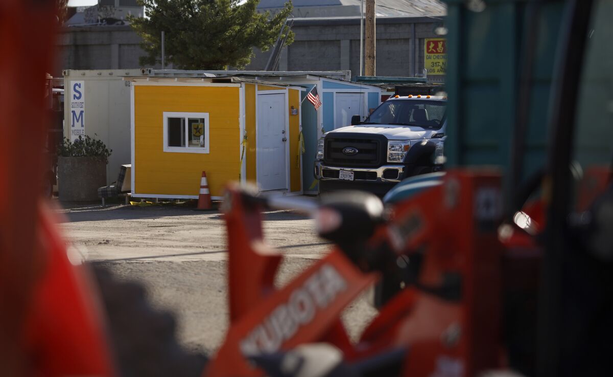 Elvis Summers' tiny homes for homeless people are stored in a an L.A. Sanitation Department lot. City sanitation workers seized tiny houses and RVs where people were living in the streets.