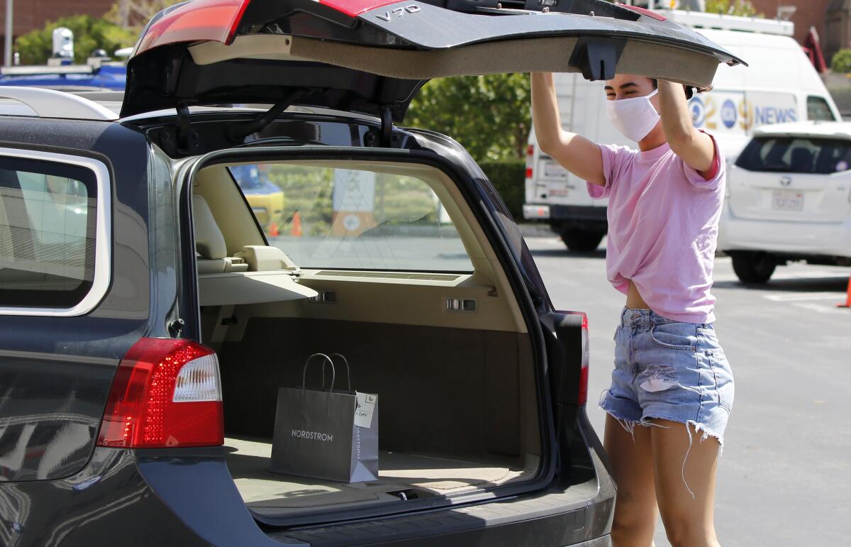 A Nordstrom customer closes her trunk after receiving the skirt she bought through her phone app at South Coast Plaza in Costa Mesa on Friday.