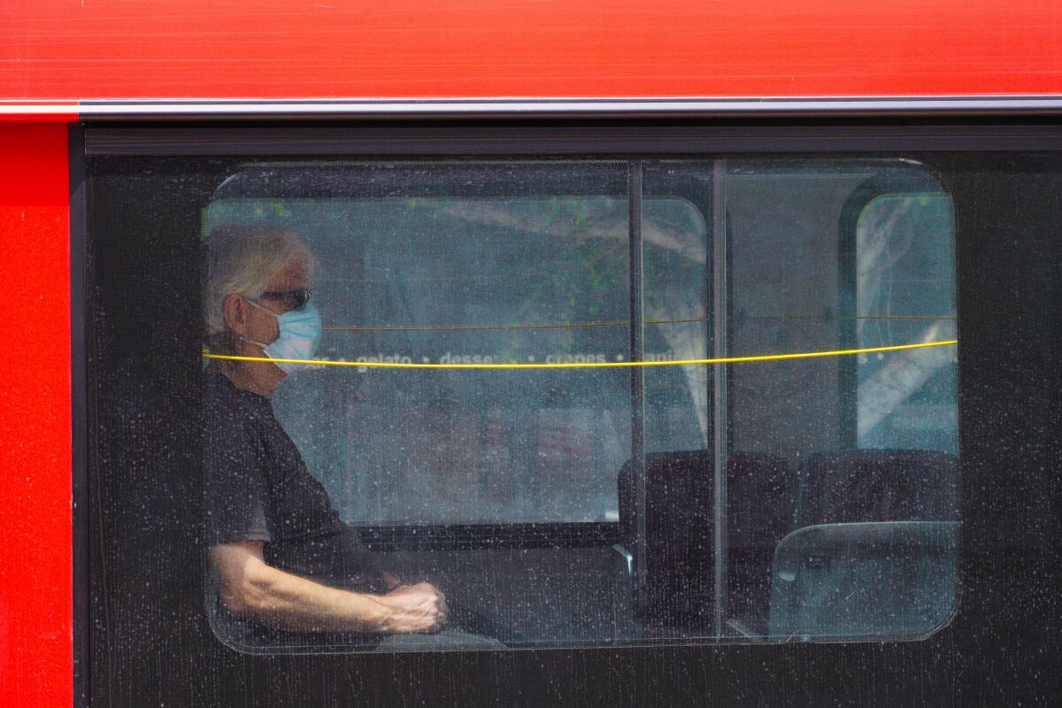At Hillcrest a passenger onboard the MTS bus wears a face mask while riding down University Avenue.
