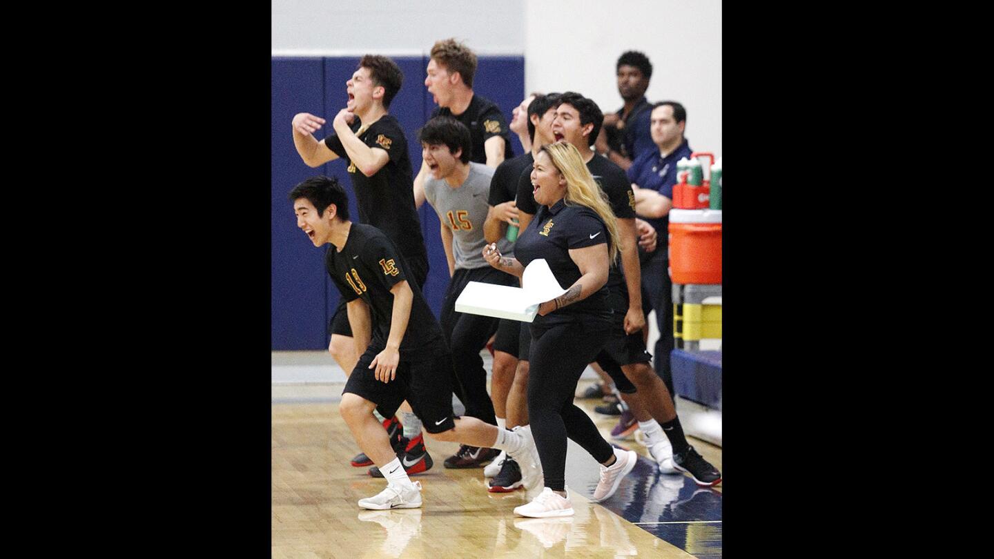 La Canada's head coach Rebecca Sanchez and the rest of the team jump to celebrate winning the fourth game against Flintridge Prep in a first round of the CIF Southern Section Division III playoff boys' volleyball match at Flintridge Prep on Tuesday, May 8, 2018. La Canada won the match 3-2.