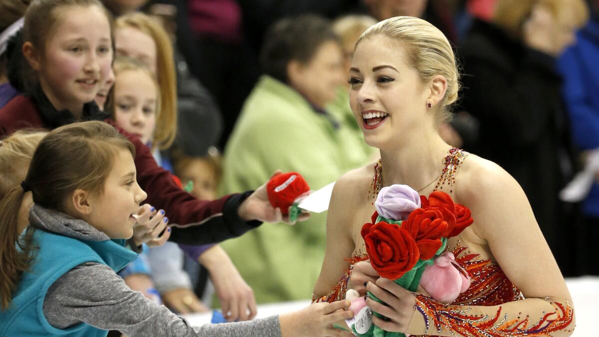 Gracie Gold collects gifts from young fans after performing in the women's free skate at the U.S. Figure Skating Championships on Saturday night in St. Paul, Minn.