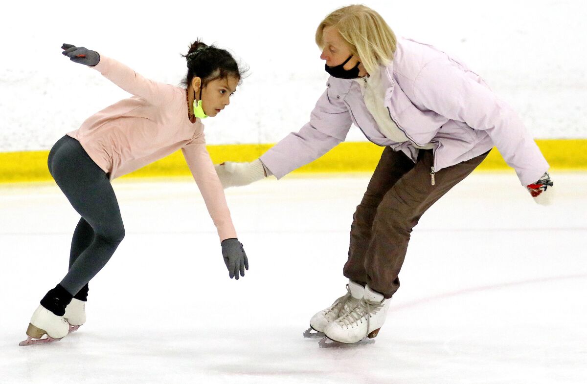 Coach Vera Arutyunyan, right, works with skater Sophia Carlos, 9, left, during practice at Great Park Ice